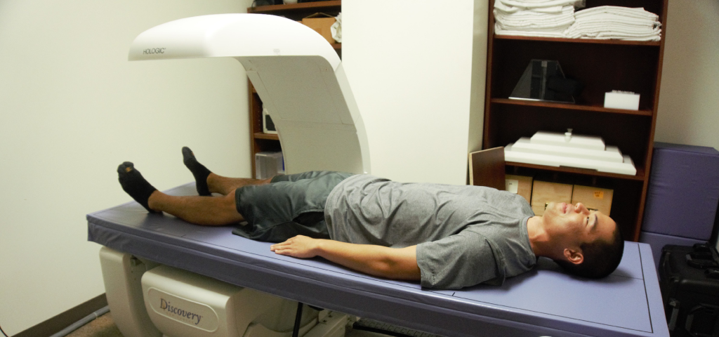 A participant lying on a DXA scanner table during a body-composition scan at the Body Composition Lab